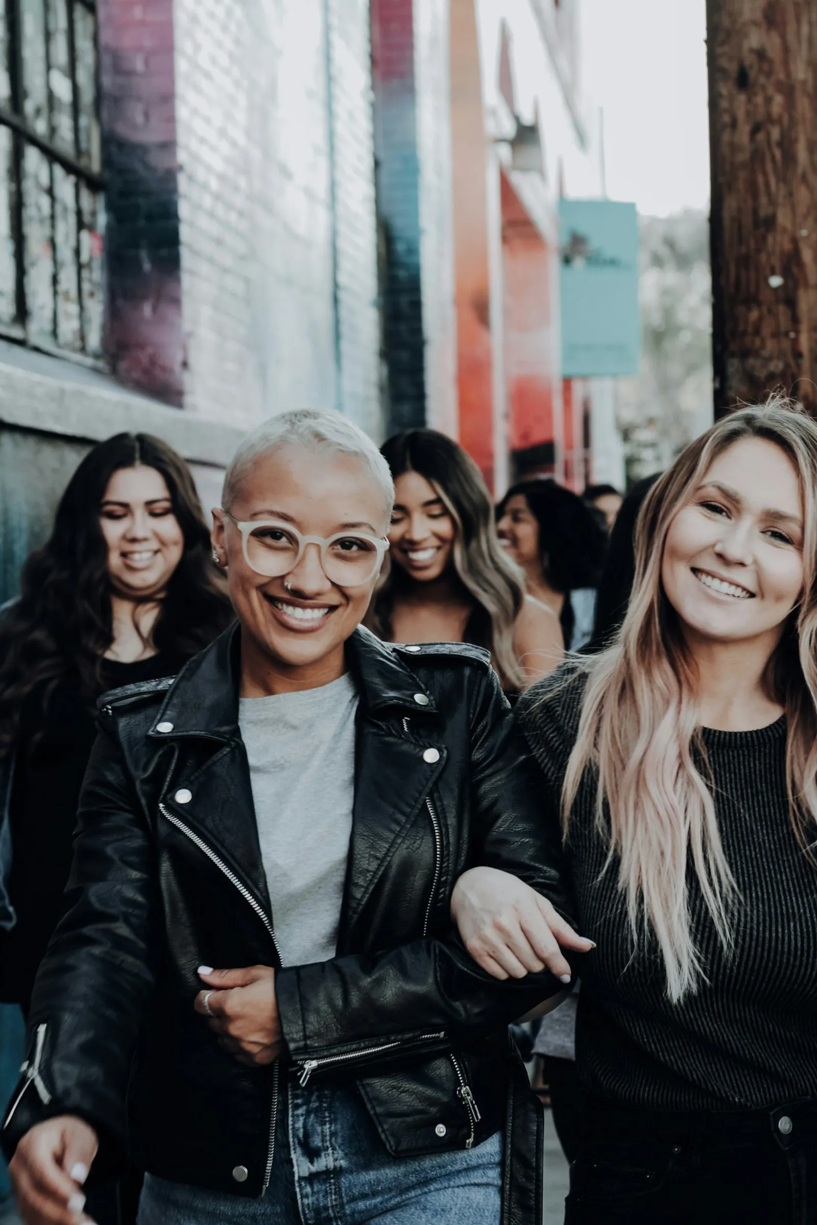 A group of friends walking together down a city street, laughing
